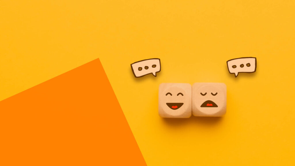 Zwei Würfel mit einem lachenden und traurigem Gesicht.